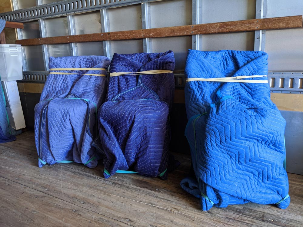Chairs wrapped in furniture blankets to protect from damage