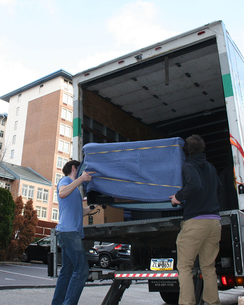 Broad Street Movers professionals meticulously loading furniture, wrapped in protective blankets, into the moving truck with precision and care