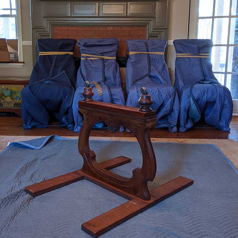Broad Street Movers performing Philadelphia junk removal services while additional chairs are wrapped for top-rated moving service.