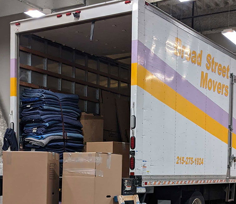 A Broad Street Movers truck parked in a garage of a building and being carefully unloaded for a Philadelphia area resident and valued Broad Street Movers customer.